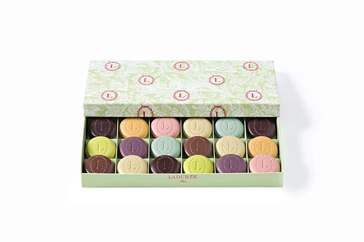 A box of high-end macaron-like biscuits by Ladurée Biscuits called The Eugénie with a variety of flavors, including pistachio, rose, and chocolate. Gluten-Free.