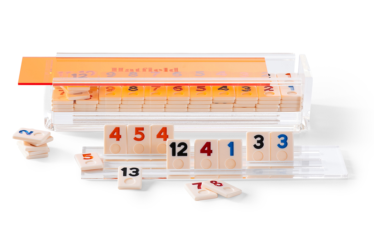 Rummikub tile game remade by monogram speicialists Mark & Graham. An acrylic box with a personalized transparent neon pink, orange, or blue lid that can be personalized.