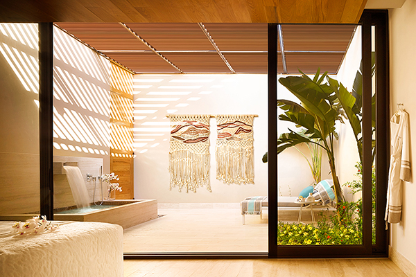 A serene and peaceful treatment room in a spa. The room has a minimalist design with neutral tones and wooden accents. 